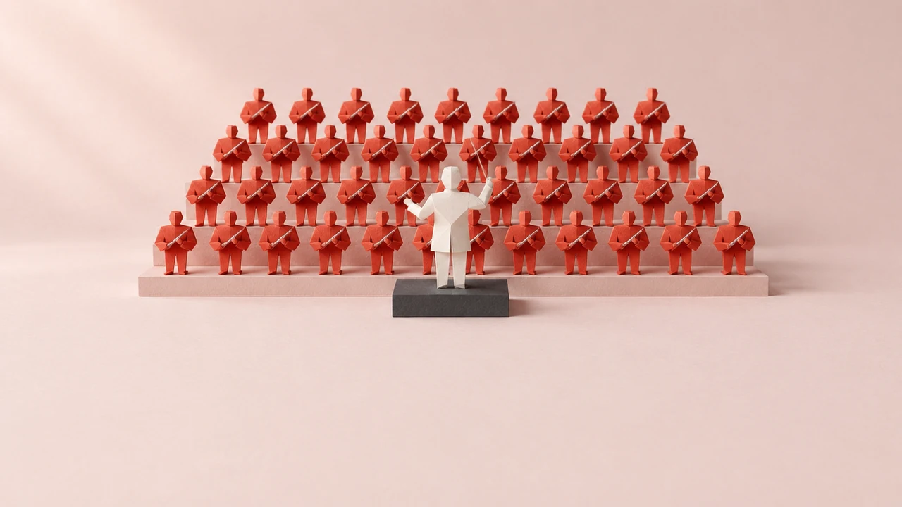 A faceless paper conductor on a low podium, baton raised, leads rows of identical small red paper figures on tiered risers
