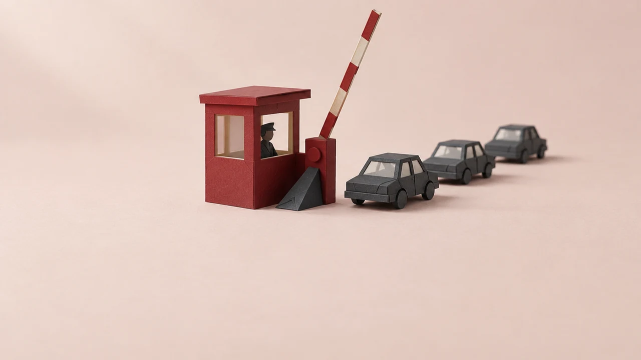 At a checkpoint booth, a striped barrier arm is wedged upright while a line of small cars drives through the open lane unchecked