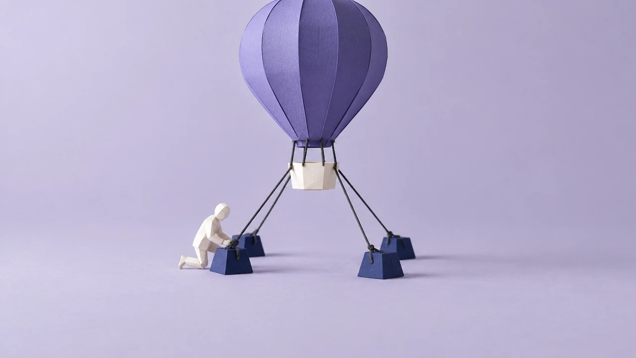 A large violet hot-air balloon strains upward, held by four taut ropes to heavy anchors, as a figure checks one knot