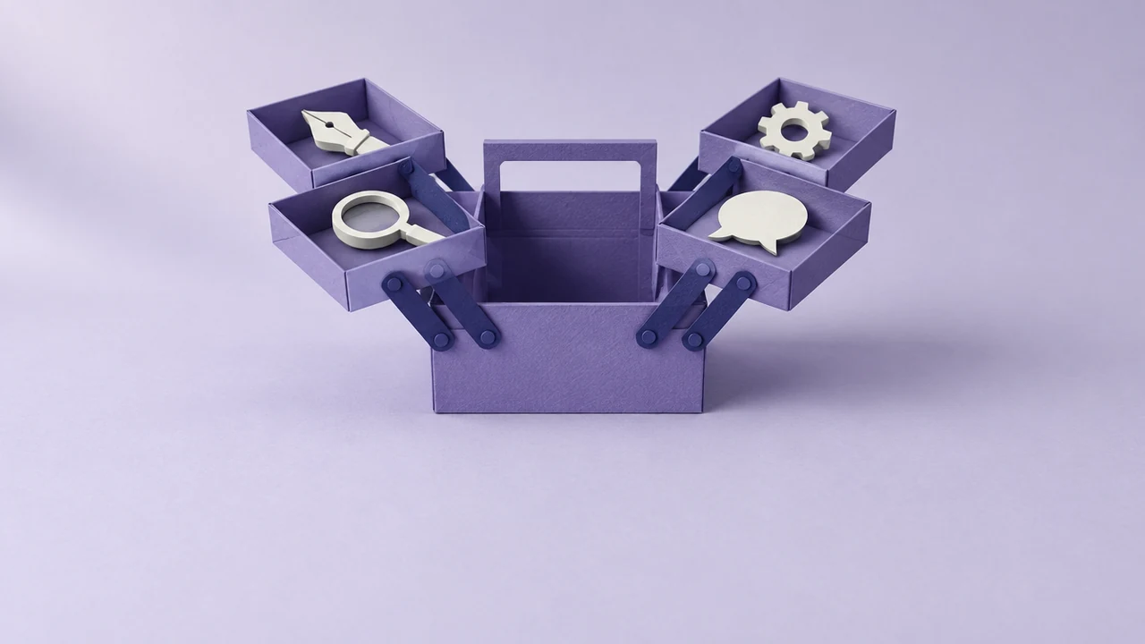 An open violet toolbox with trays fanned out, each holding one simple tool: a pen nib, a magnifying lens, a cog and a speech bubble